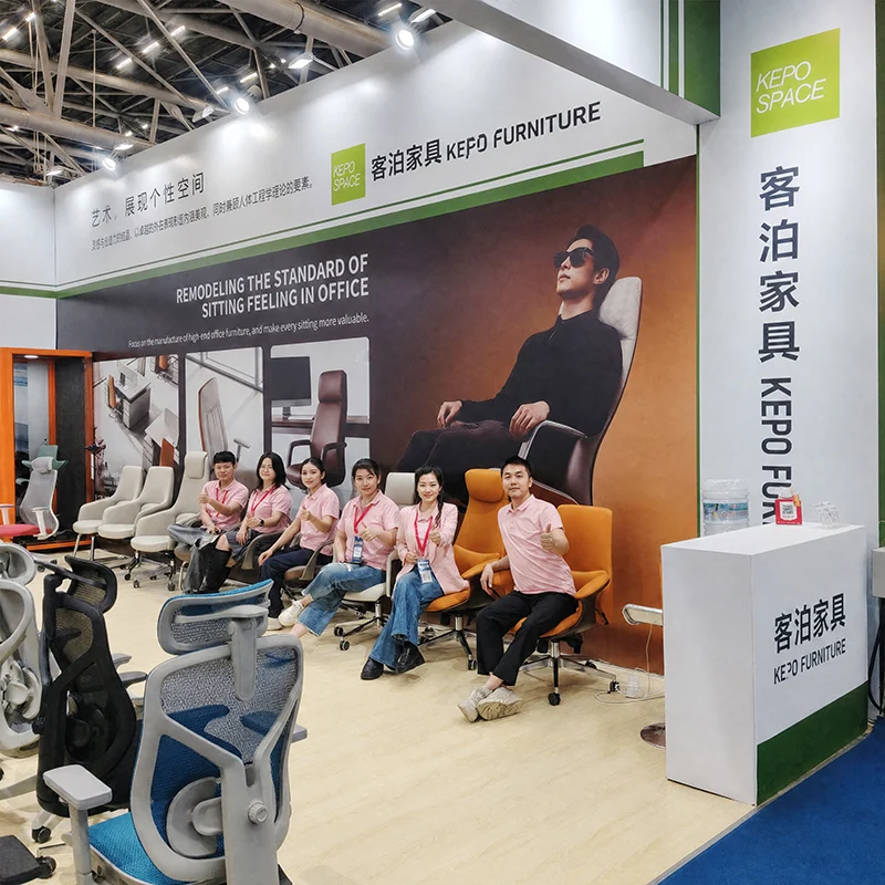 KEPO-SPACE team photo at furniture fair booth with ergonomic office chair display