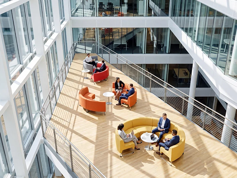 Colorful modular lounge sofas in multi-level modern office building for meeting and breakout zones