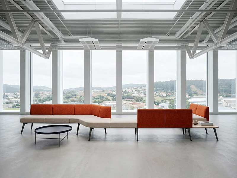 Modern modular office lounge booth sofa set in bright open office space with large windows